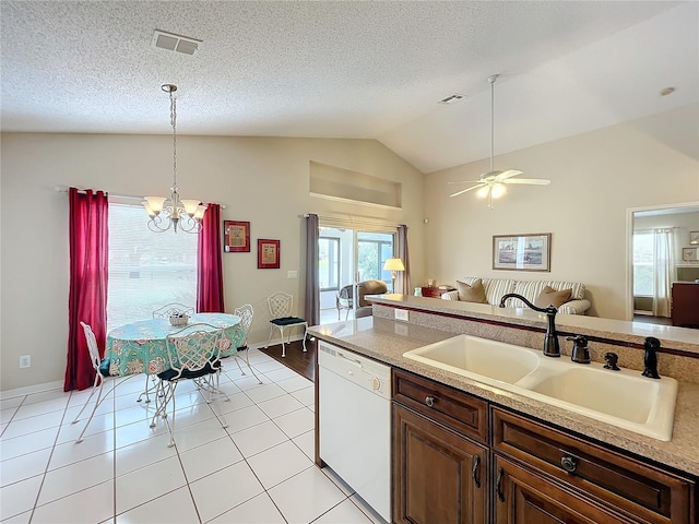 kitchen with dishwasher, sink, vaulted ceiling, light tile patterned floors, and decorative light fixtures