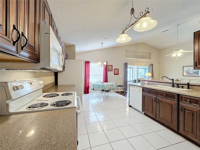 kitchen with sink, vaulted ceiling, a textured ceiling, white appliances, and ceiling fan with notable chandelier