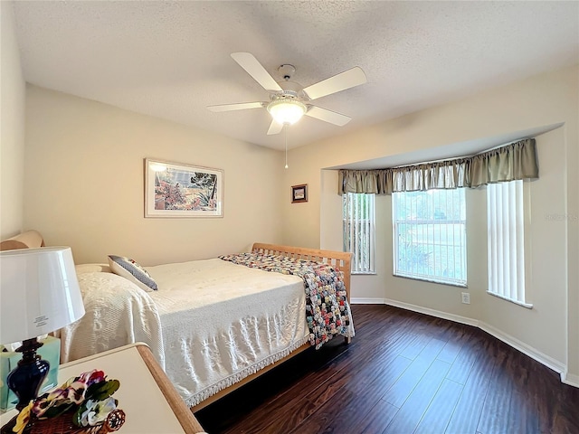 bedroom featuring a textured ceiling, ceiling fan, and dark hardwood / wood-style floors