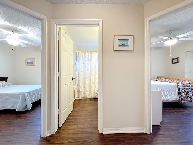 corridor featuring dark hardwood / wood-style flooring and a textured ceiling