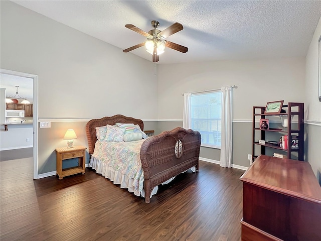 bedroom featuring vaulted ceiling, ceiling fan, a textured ceiling, and dark hardwood / wood-style floors