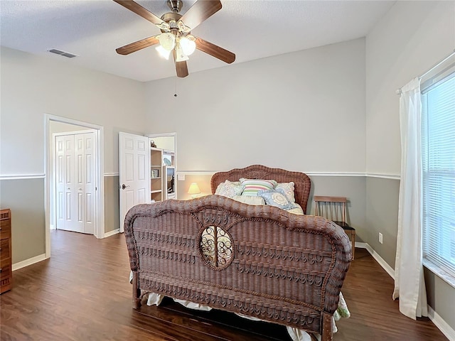 bedroom featuring dark hardwood / wood-style flooring, multiple windows, and ceiling fan