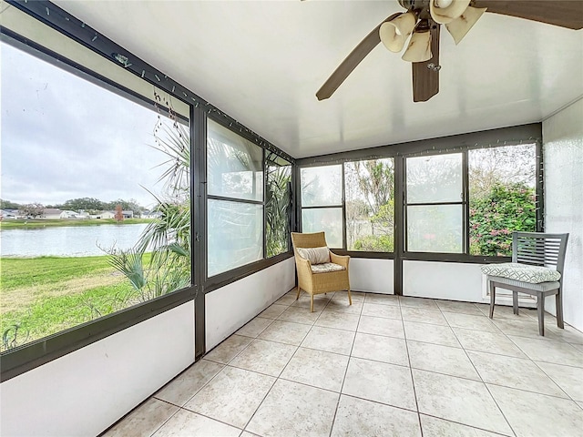 unfurnished sunroom with a water view and ceiling fan