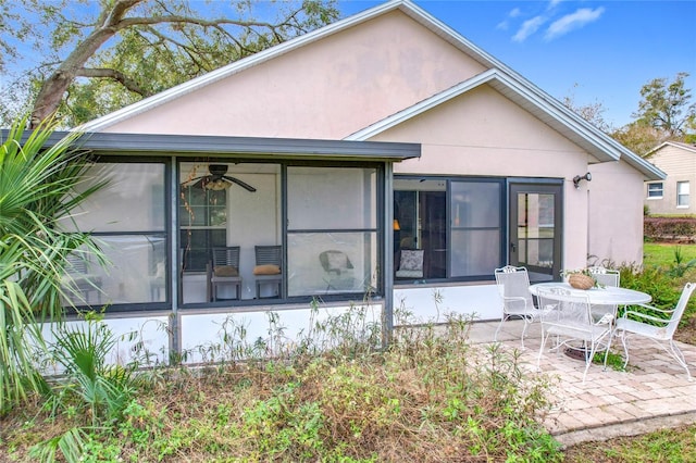 back of property featuring a sunroom, ceiling fan, and a patio area