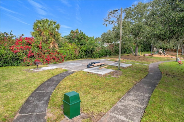 view of property's community with a lawn and a playground