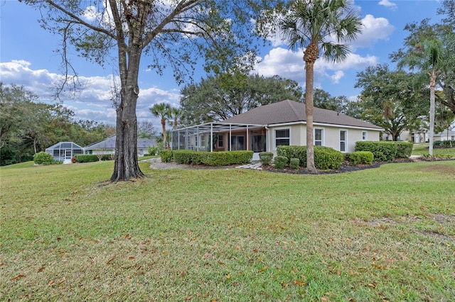 view of front of house with glass enclosure and a front lawn