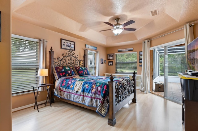 bedroom with access to exterior, ceiling fan, a textured ceiling, and light wood-type flooring