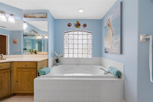 bathroom featuring tile patterned floors, tiled tub, and vanity