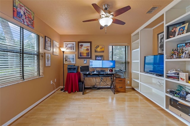 office featuring a textured ceiling, light hardwood / wood-style flooring, and ceiling fan