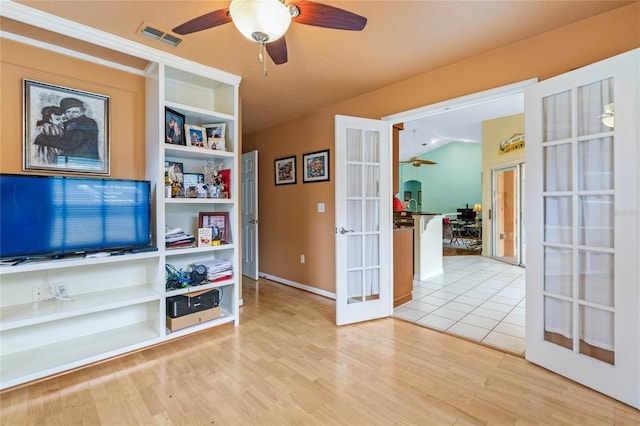 interior space with ceiling fan, french doors, vaulted ceiling, and light hardwood / wood-style flooring