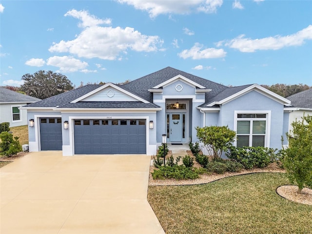 view of front of home with driveway, a garage, stucco siding, roof with shingles, and a front yard