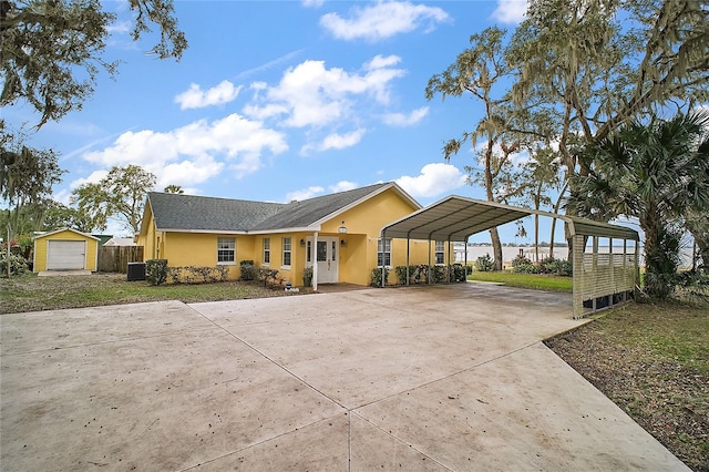 view of front of house featuring an outdoor structure, cooling unit, a front yard, and a carport