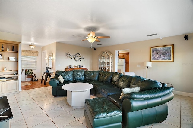 living room featuring ceiling fan and light tile patterned flooring