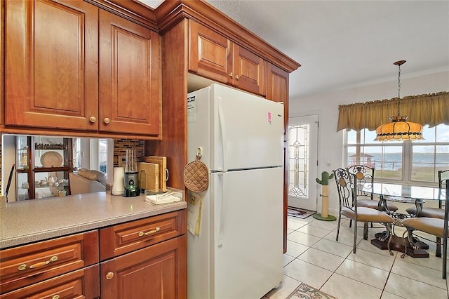 kitchen featuring decorative light fixtures, white refrigerator, and light tile patterned floors