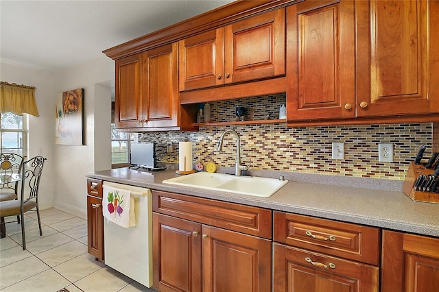 kitchen featuring light tile patterned floors, white dishwasher, tasteful backsplash, and sink