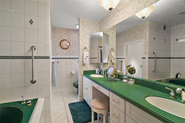 full bathroom with tile patterned flooring, a textured ceiling, toilet, vanity, and tile walls