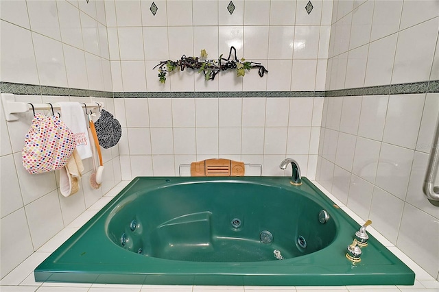 bathroom featuring a relaxing tiled tub and tile walls