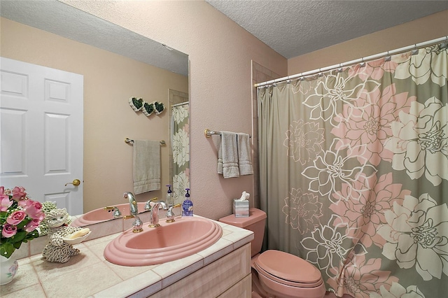 bathroom with vanity, a textured ceiling, and toilet