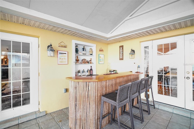 bar featuring built in features and french doors