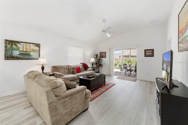 living room with ceiling fan, light wood-type flooring, and vaulted ceiling