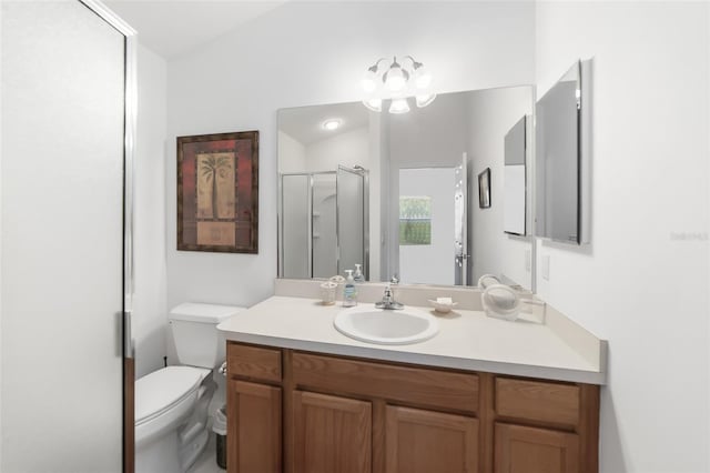 bathroom featuring vanity, a shower with shower door, and toilet