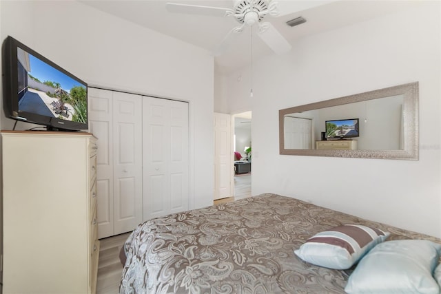 bedroom featuring ceiling fan, a closet, vaulted ceiling, and light wood-type flooring