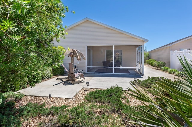 back of property with a sunroom and a patio area