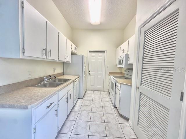 kitchen featuring a textured ceiling, sink, white cabinets, and white appliances