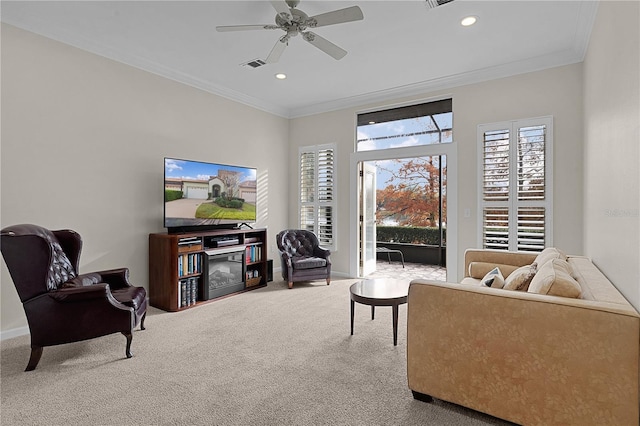 carpeted living room with ceiling fan and crown molding