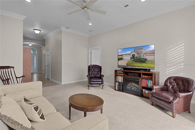 living room with light carpet, crown molding, and ceiling fan