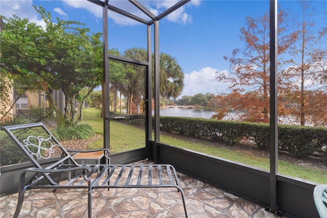 unfurnished sunroom featuring a water view