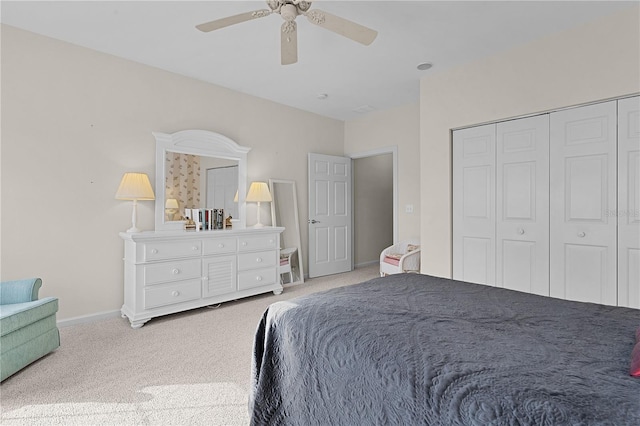 bedroom featuring ceiling fan, a closet, and light carpet