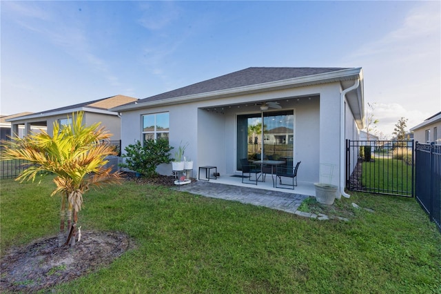 back of property featuring ceiling fan, a patio area, and a lawn