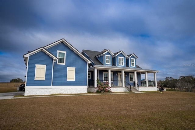 view of front of home with covered porch and a front lawn