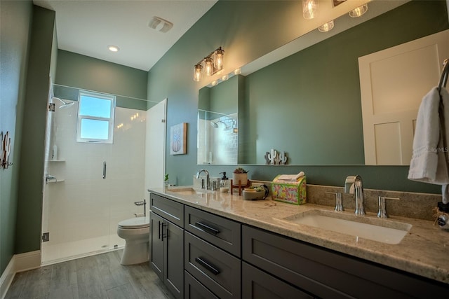 bathroom featuring vanity, hardwood / wood-style flooring, toilet, and a shower with door