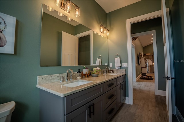 bathroom with vanity, wood-type flooring, and vaulted ceiling