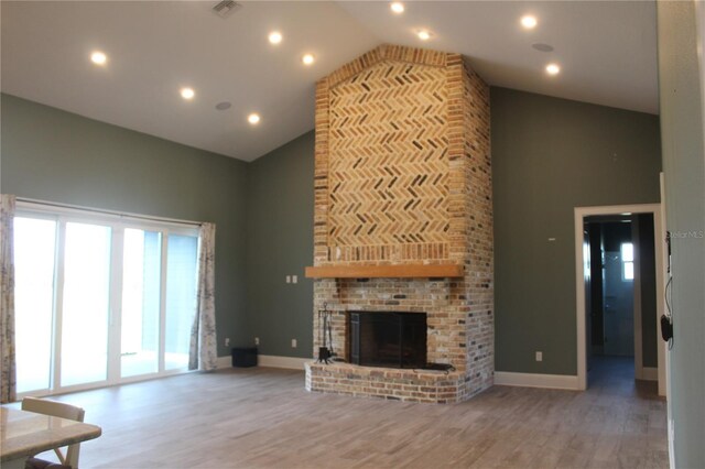 2437 Bay Lake Loop, Groveland, FL 34736 - unfurnished living room featuring a fireplace, wood finished floors, high vaulted ceiling, baseboards, and recessed lighting