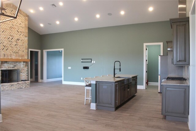 2437 Bay Lake Loop, Groveland, FL 34736 - kitchen with a breakfast bar, a sink, an island with sink, baseboards, and visible vents