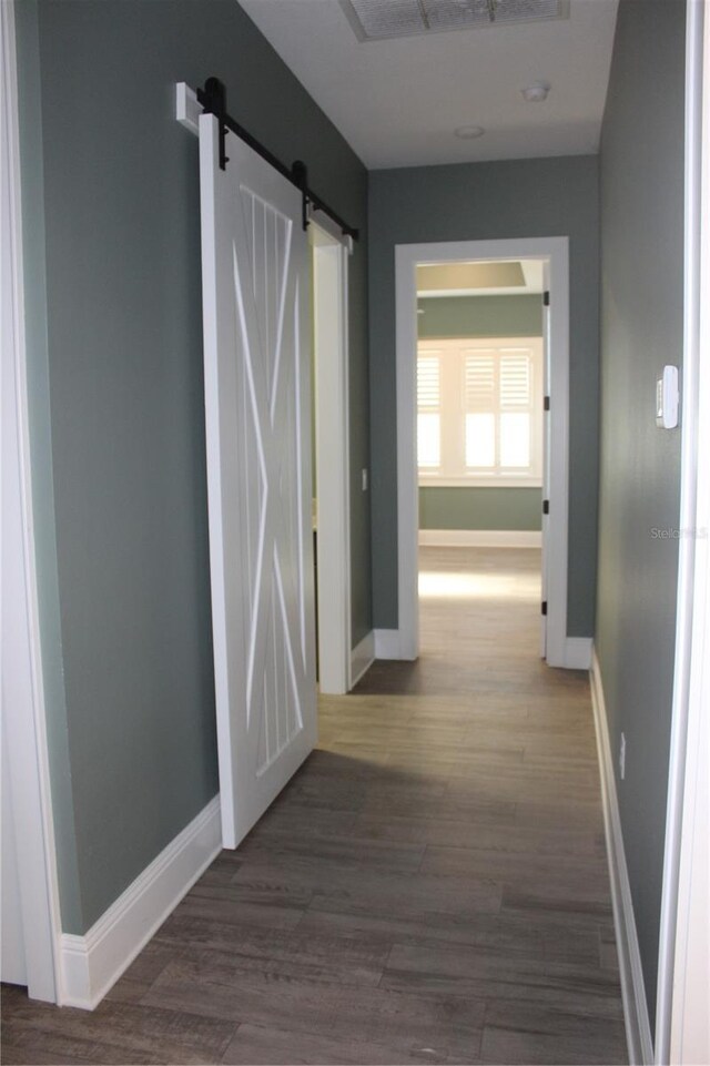 2437 Bay Lake Loop, Groveland, FL 34736 - corridor featuring baseboards, visible vents, a barn door, and wood finished floors