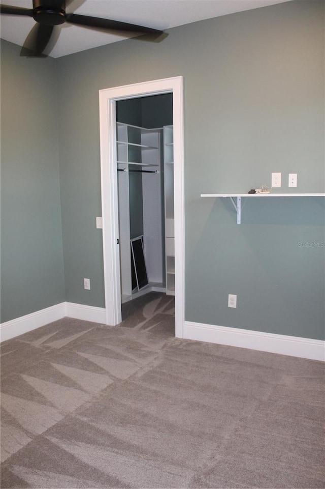 2437 Bay Lake Loop, Groveland, FL 34736 - unfurnished bedroom featuring carpet flooring, ceiling fan, a walk in closet, baseboards, and a closet