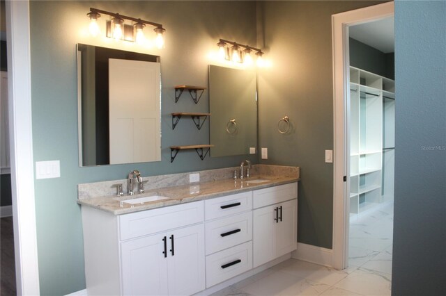 2437 Bay Lake Loop, Groveland, FL 34736 - bathroom with double vanity, baseboards, a sink, and marble finish floor