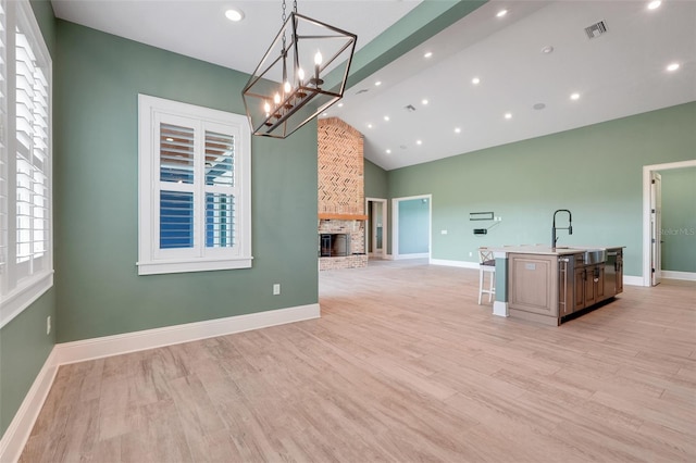 2437 Bay Lake Loop, Groveland, FL 34736 - kitchen featuring open floor plan, an island with sink, recessed lighting, a fireplace, and light wood-style floors