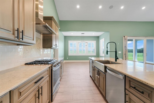 2437 Bay Lake Loop, Groveland, FL 34736 - kitchen featuring appliances with stainless steel finishes, wall chimney range hood, decorative backsplash, light stone counters, and recessed lighting