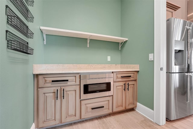 2437 Bay Lake Loop, Groveland, FL 34736 - kitchen with stainless steel appliances, light wood finished floors, light stone countertops, and open shelves