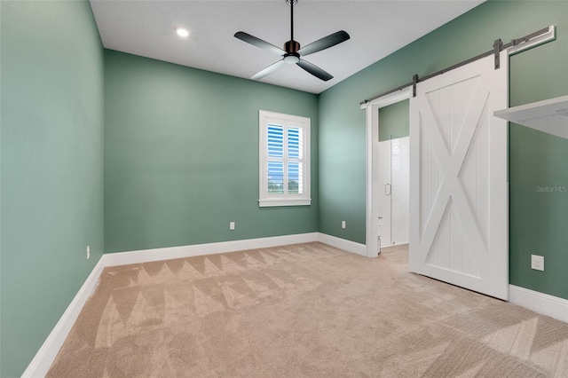 2437 Bay Lake Loop, Groveland, FL 34736 - unfurnished bedroom with a barn door, carpet flooring, and ceiling fan