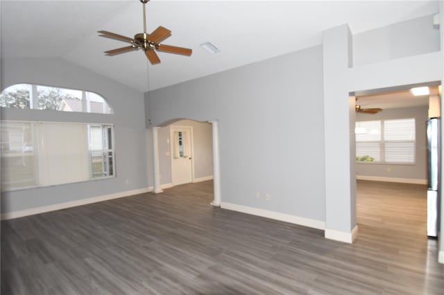 unfurnished living room featuring ceiling fan, plenty of natural light, dark hardwood / wood-style flooring, and decorative columns