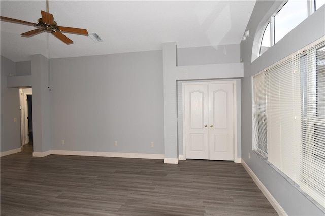 unfurnished bedroom featuring ceiling fan, dark hardwood / wood-style floors, high vaulted ceiling, and a closet