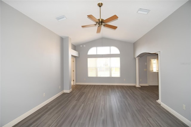 empty room with ceiling fan, high vaulted ceiling, dark hardwood / wood-style flooring, and decorative columns