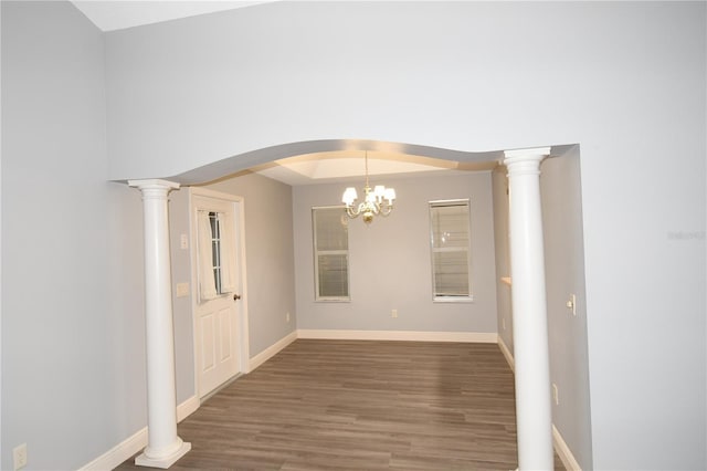 unfurnished dining area featuring dark hardwood / wood-style flooring and decorative columns