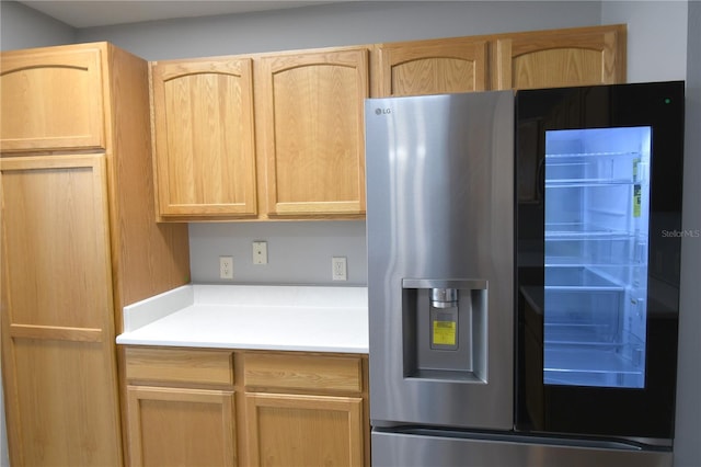 kitchen with light brown cabinetry and stainless steel refrigerator with ice dispenser